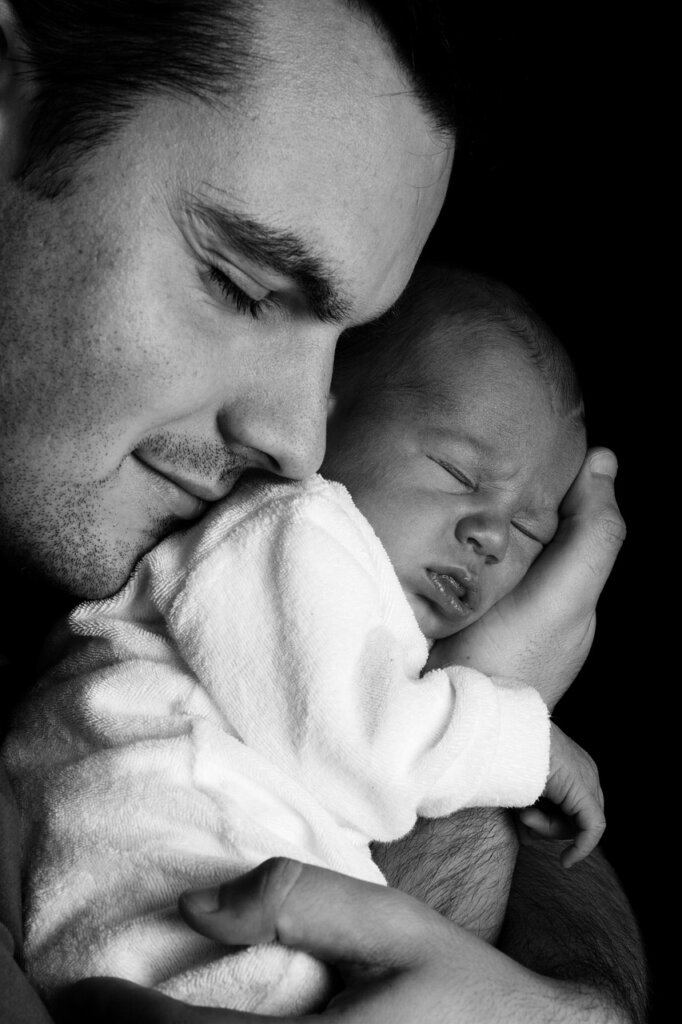 father holding baby while reviewing financial documents