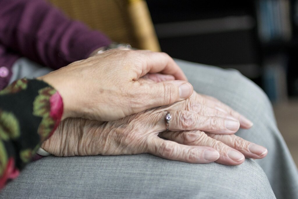 middle-aged Korean daughter helping elderly mother fill out welfare application form