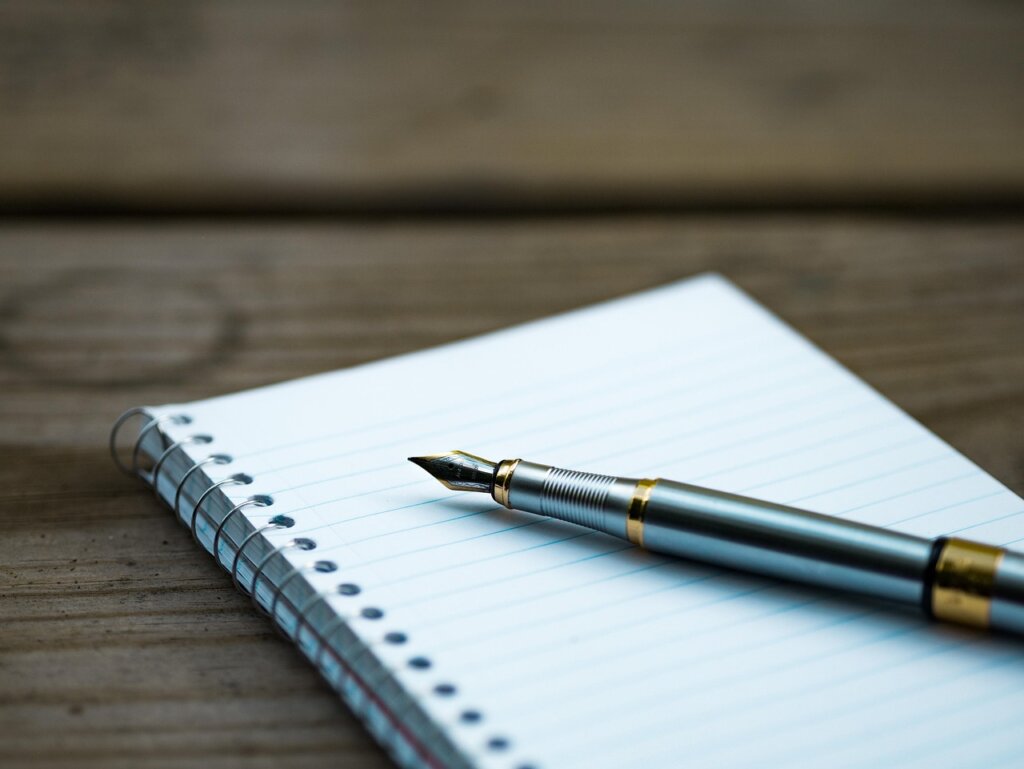 checklist notebook with pen and calculator on wooden desk