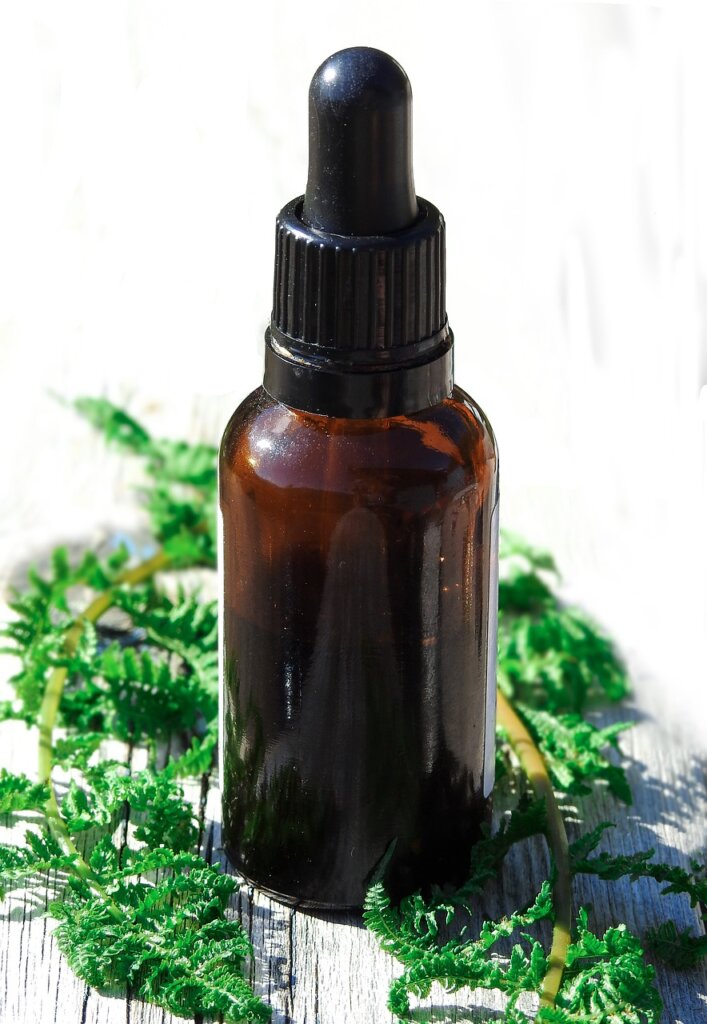clove essential oil dropper on wooden surface