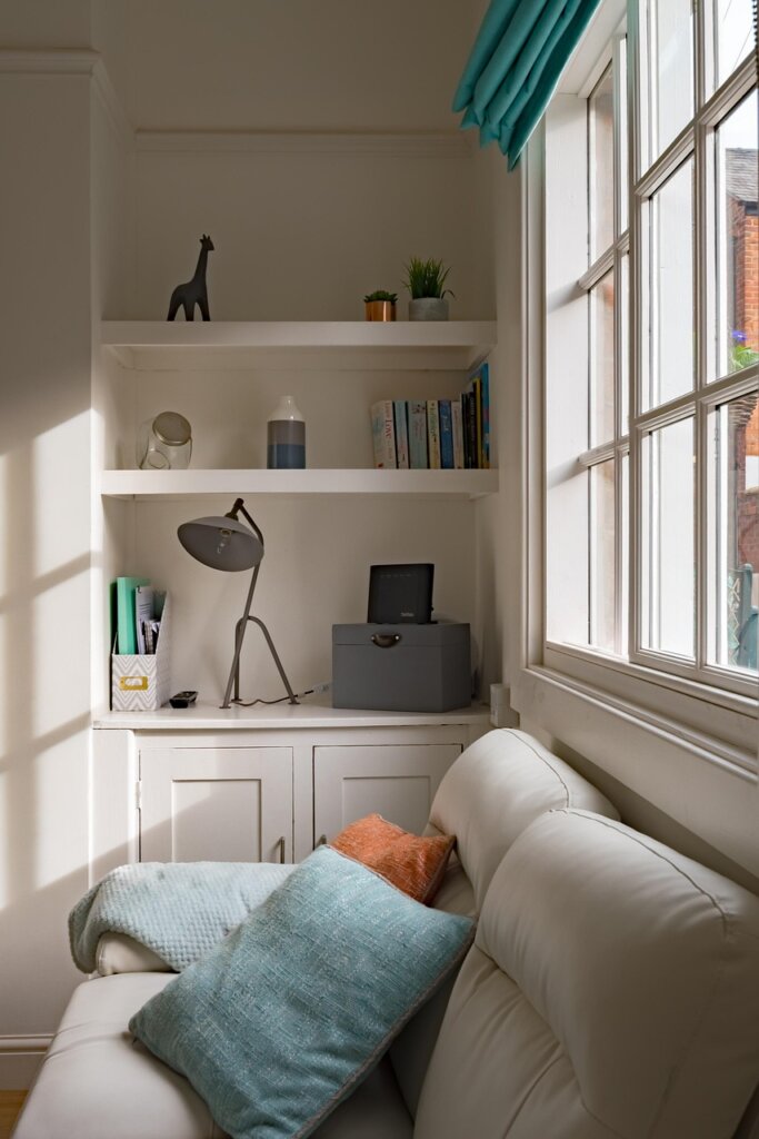 woman wiping condensation from window in cozy winter apartment