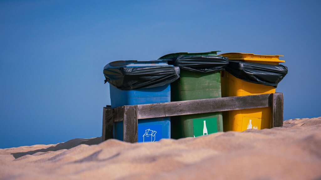 recycling bins labeled for plastic paper styrofoam vinyl outdoors