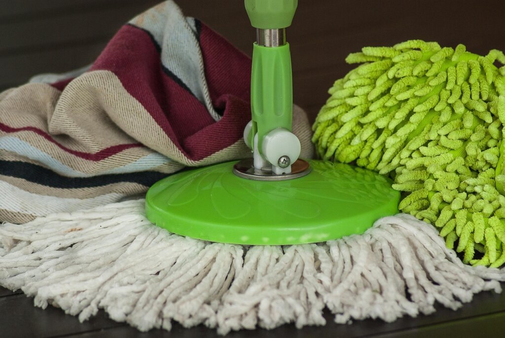 person cleaning microwave with cloth after steam method
