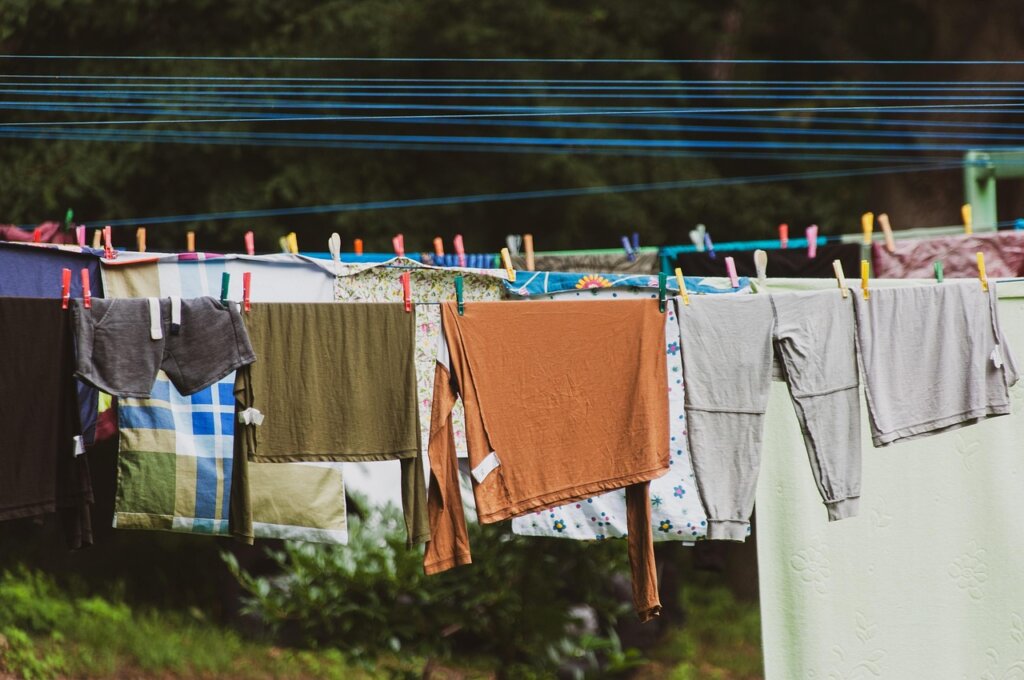 person air drying a white shirt on a clothesline outdoors