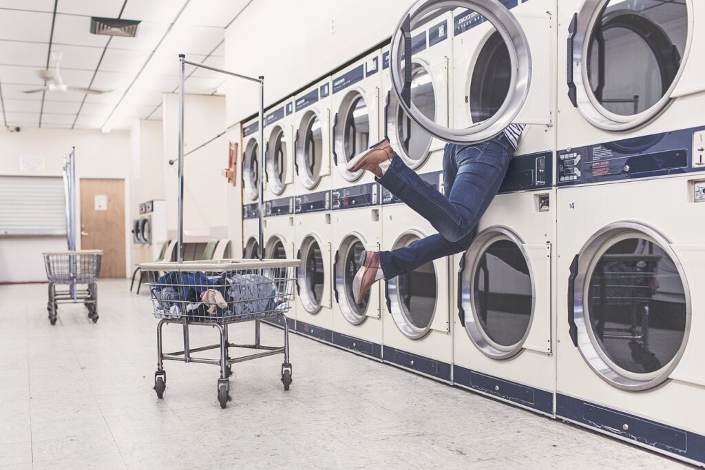 electric dryer machine running in laundry room with power cord visible