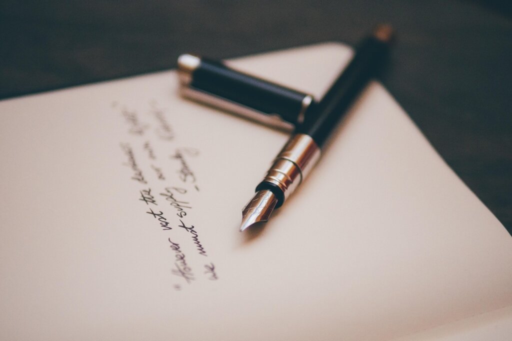 handwritten monthly expense notebook with receipts beside it
