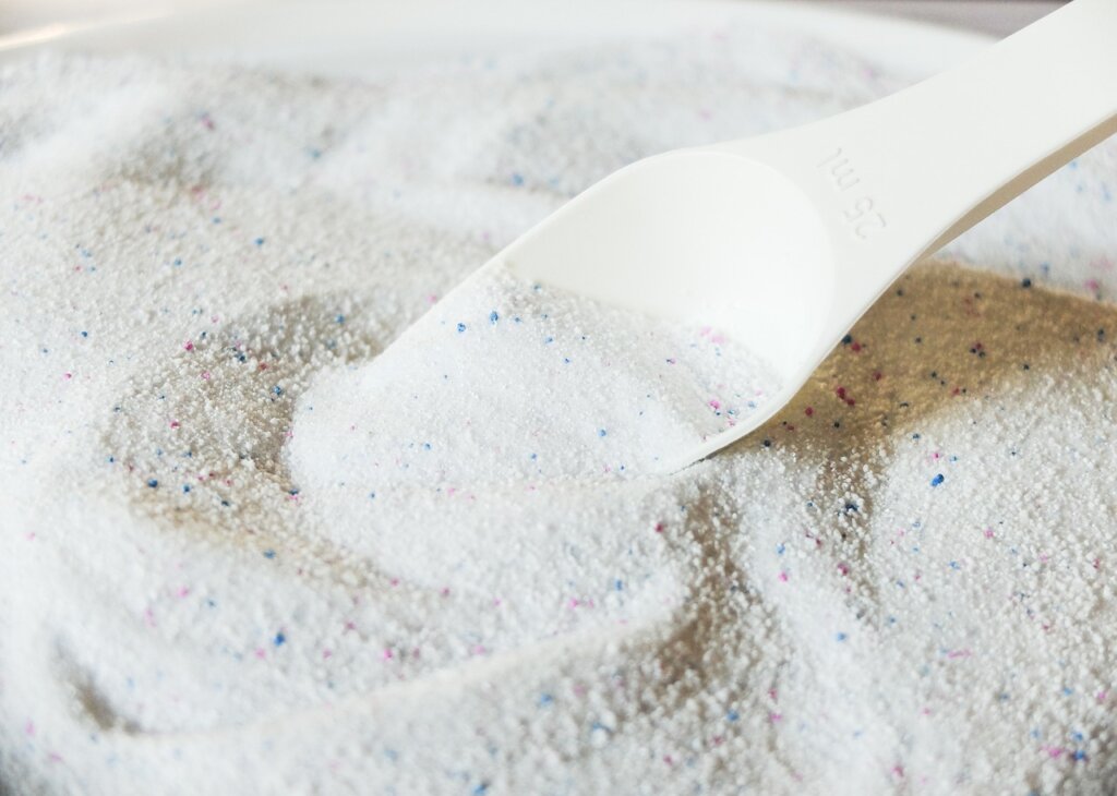 liquid detergent being measured carefully into cap